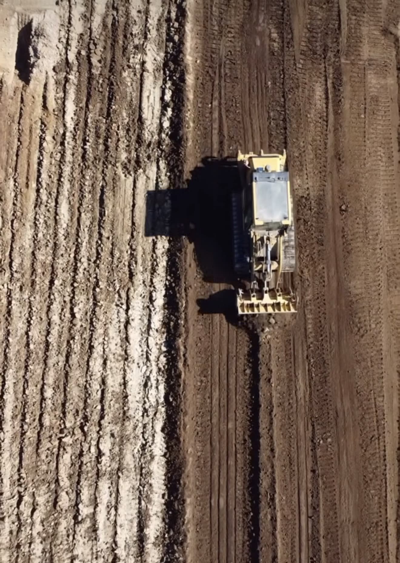 Aerial of a CAT dozer shaping a fresh pad and access