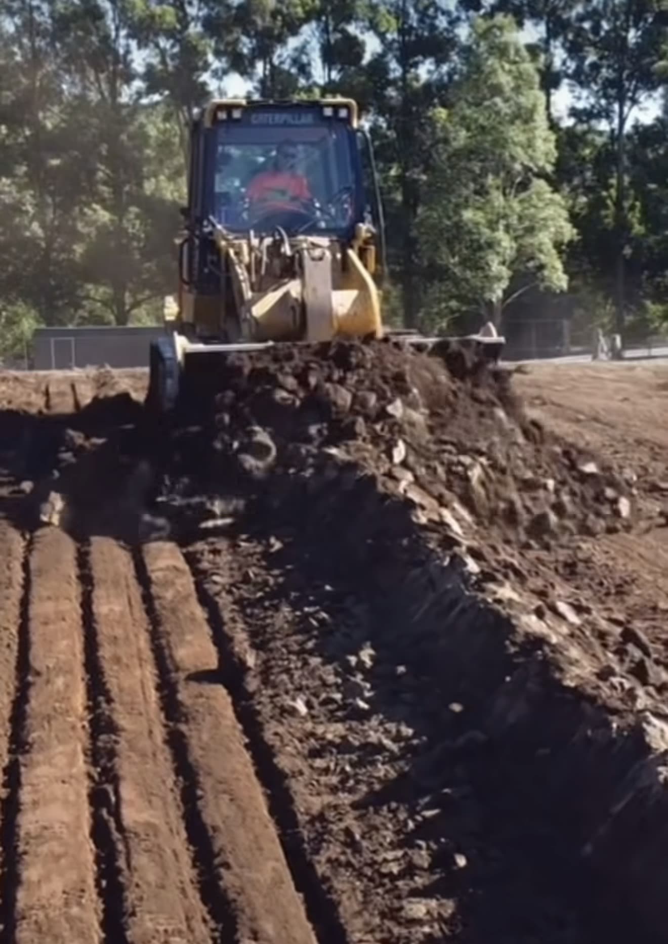 CAT dozer pushing the last of the spoil off the edge of a fresh pad