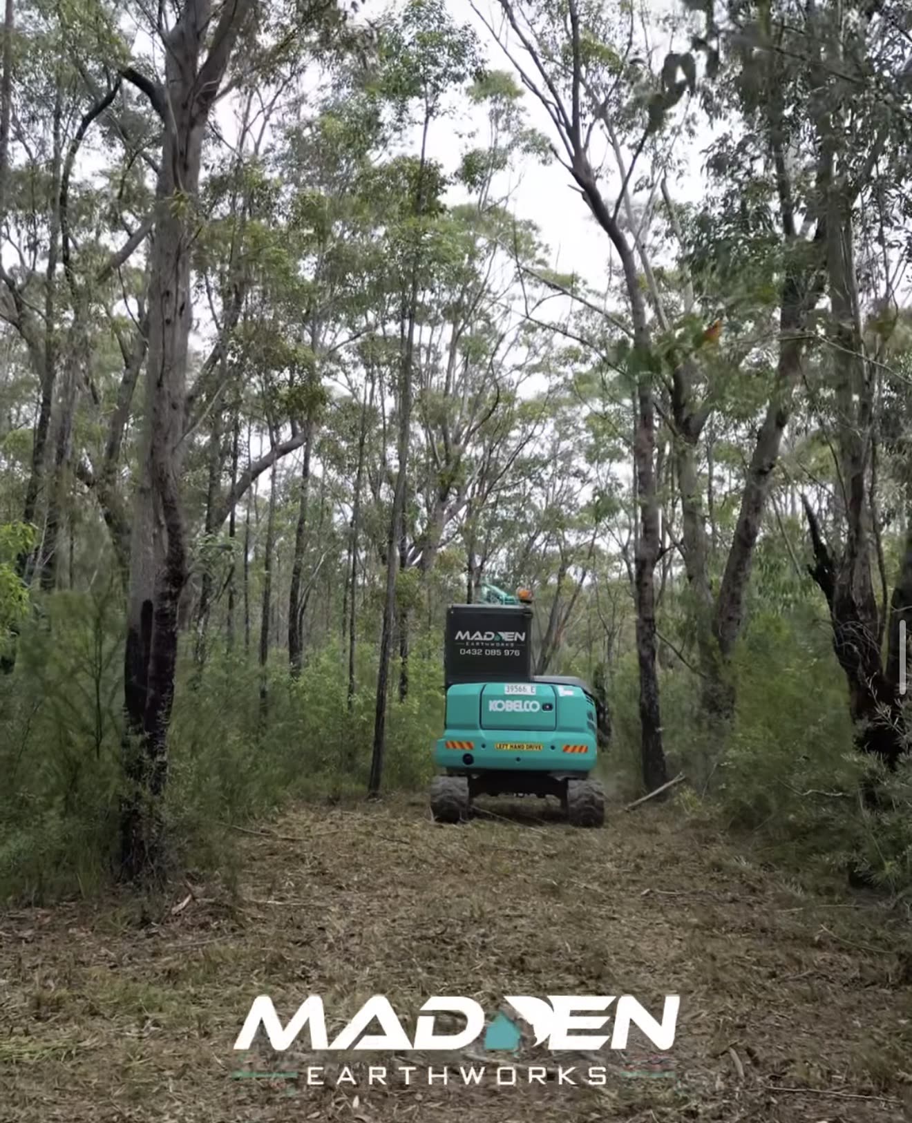 Teal Kobelco excavator clearing bush scrub on a rural Hawkesbury property