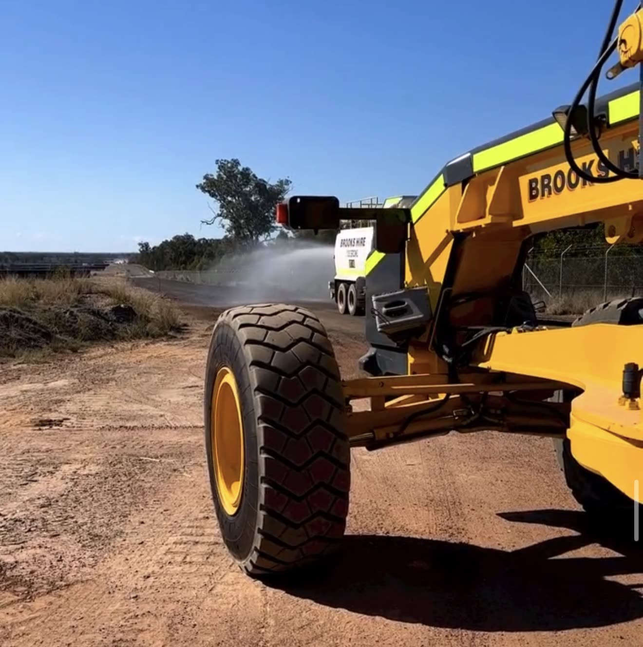 Grader and water truck working a remote haul road