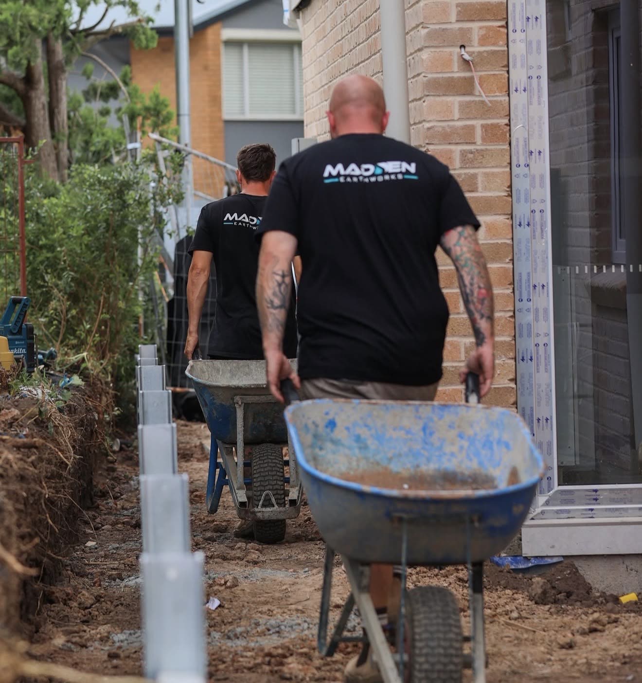 Madden Earthworks team working a tight-access residential site with wheelbarrows