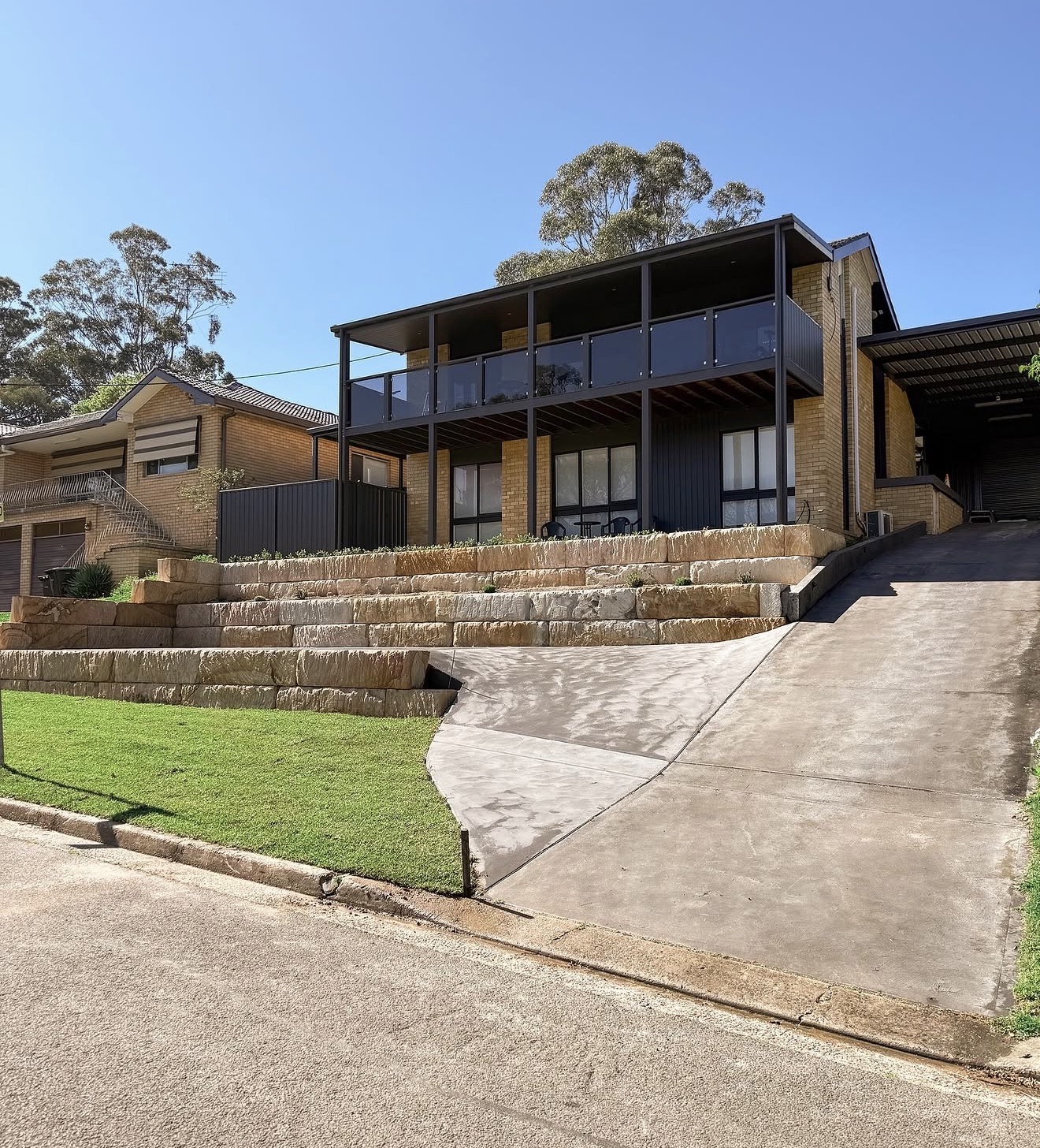 Finished two-tier sandstone block retaining wall with driveway - Hawkesbury NSW